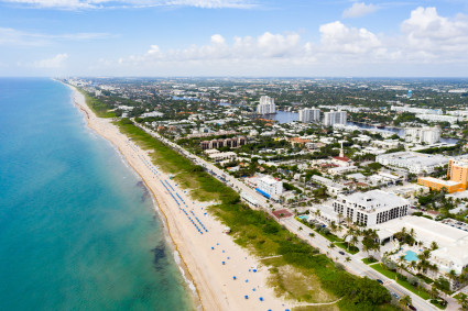 Aerial view of a long, ocean beach with a town