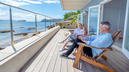 A luxury timeshare with a patio, pool and lush greenery.