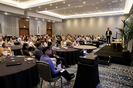 Photo of Pacaso crew in the meeting hall with Austin presenting at the front of the room during our Denver retreat. 