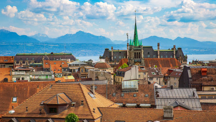 The steeple of a cathedral sticks out among the other medieval buildings in Lausanne, one of the best vacation spots for couples. 