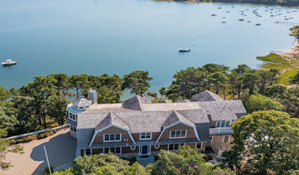 Aerial view of a large waterfront estate surrounded by trees.
