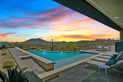 A luxury infinity pool at a Scottsdale-area home at dusk, showcasing the serene and private experience of fall desert evenings.