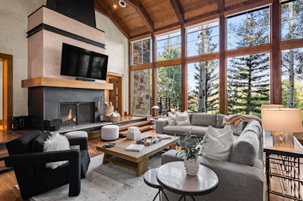 Grand living room at Crystal showcases vaulted timber, a fireplace, and views that frame Telluride's peaks.