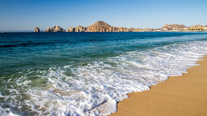 A stock photo shows the tide coming in on Medano Beach.