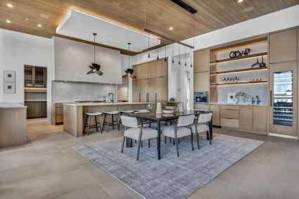 Contemporary vacation home kitchen and dining space with a waterfront view, showcasing elegant decor.