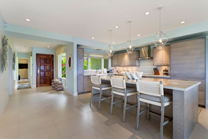 A modern gourmet kitchen with a large island and ocean views at Lani, a Pacaso home in Lahaina, Maui.