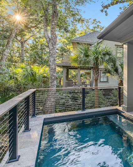 Oyster Rake outdoor plunge pool with covered lounge area with patio furniture arranged in a circle.
