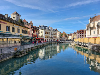 Restaurants and shops along a canal on a sunny day.