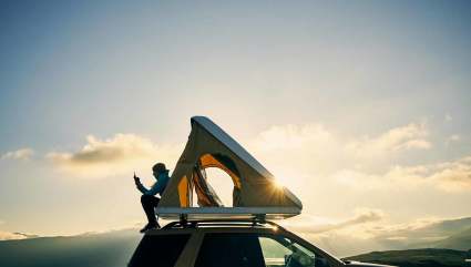 A person sets up a tent on top of their car at Routt National Forest, one of the top places for Steamboat Springs summer activities.