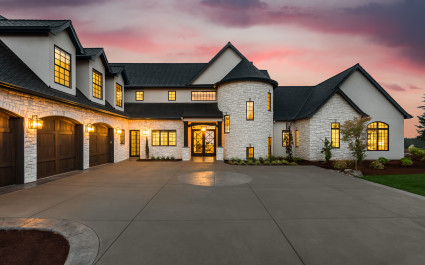 Beautiful Luxury Home Exterior at Twilight with Colorful Sunset Sky