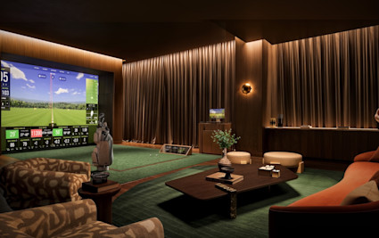 Dimly lit indoor golf simulator room with large screen display, hitting mat, golf bag, and lounge seating with warm wood and green accents.