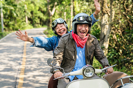 Senior couple riding a scooter on vacation