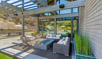 An outdoor deck with lounge furniture and a fire pit.
