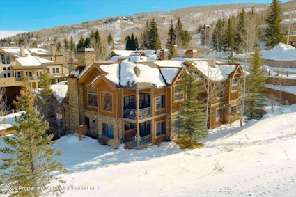 A stunning snowy aerial view at 425 Wood Road58, Aspen, CO 81611, capturing the essence of elevated living and the breathtaking landscapes that complement the Snowmass Balloon Festival.