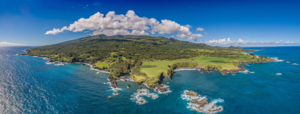 Aerial view of a large, green island and clear blue water