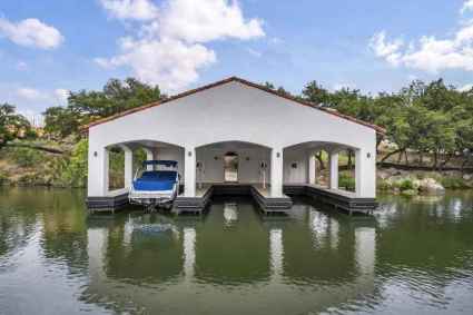 A boat house on the water with a dock, providing a serene and picturesque setting for water activities.