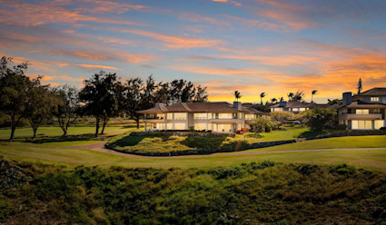 Exterior of home on golf course with a colorful sunset sky.