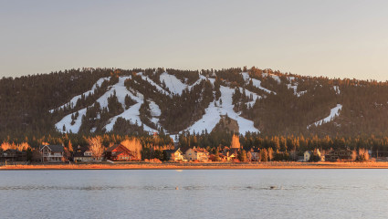 Houses sit at the beachfront with a nearby mountain in the background at Big Bear, California, embodying why it’s one of the best places for a second home.