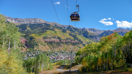 Telluride gondola over golden aspens highlights easy movement between town and the mountain for four-season living.