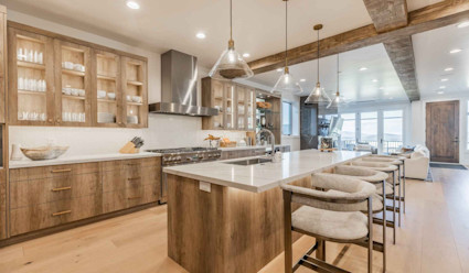 A brightly lit kitchen with wooden cabinets and an island. 