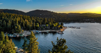 Aerial view of a mountain lake with boats and docks at dusk