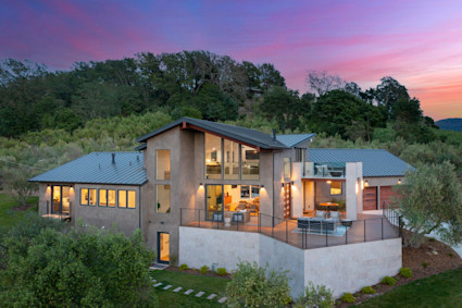 Elegant back house at dusk with a welcoming patio and outdoor hangout space, perfect for gatherings during Sonoma's wine country harvest season.