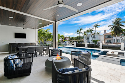 An inviting Fort Lauderdale patio with an outdoor living space and fire pit, representing the type of secure, private amenities ideal for lock-and-leave ownership.