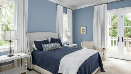 Before-and-after transformation of a Surfsong guest bedroom, evolving from moody blue tones to a serene, light-filled retreat with treetop views.Before-and-after transformation of a Surfsong guest bedroom, evolving from moody blue tones to a serene, light-filled retreat with treetop views.