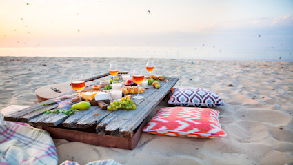 A beach picnic scene with fresh fruit and cheeses, reflecting the relaxed elegance and gourmet possibilities of a private chef experience in a Pacaso coastal home.