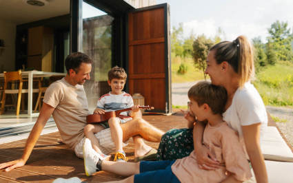 A family sits on the deck of their l	luxury vacation home.