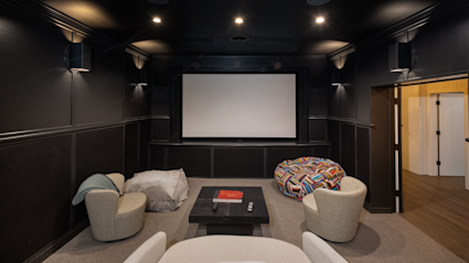 A home theater room with a large screen and black walls, perfect for an immersive movie experience
