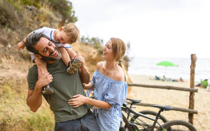 A family embraces while enjoying a day at the beach.