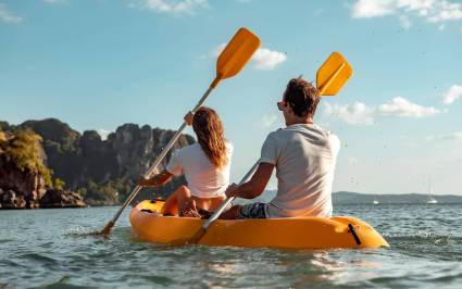 Two people kayak while enjoying a luxury vacation.