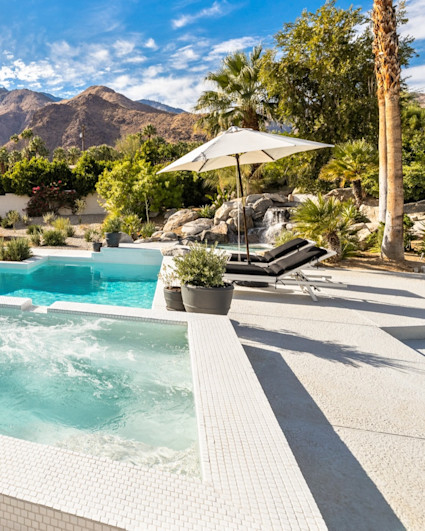 View of The Oasis pool area with surrounding palm trees and mountain views.