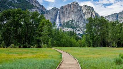 A boardwalk crosses a meadow with El Capitan rising in the distance, one of the best spring break ideas for families. 