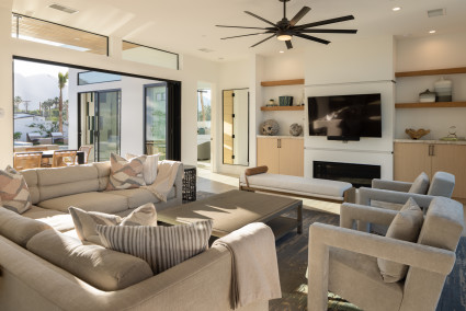 Living room with modern furnishings and doors that open to a large outdoor space