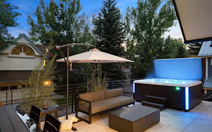 Mountain home patio with an outdoor fireplace overlooking snowy peaks near Aspen, Colorado