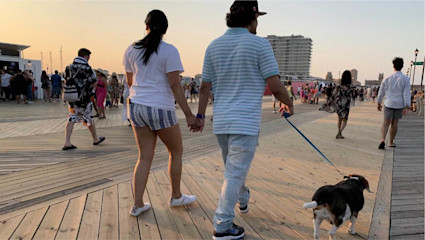 A playful pup walks along the Jersey Shore boardwalk, where ocean views make it a top spot for a pet-friendly holiday.