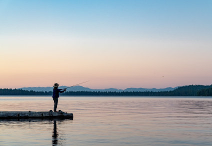 A person stands on a dock to fish at Lake Tahoe.