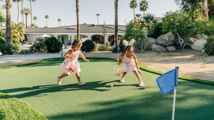 Two young children collecting Easter eggs on the putting green at a second home estate in Palm Springs. 