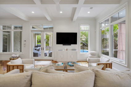 Seaside’s living room in Hilton Head is a study in refined elegance, with coffered and beamed ceilings drawing the eye upward and French doors opening to inviting coastal breezes.