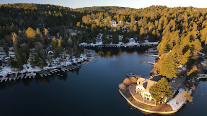 Aerial winter view of Lake Arrowhead highlights the intimate shoreline and forested setting that appeals to buyers seeking privacy and easy access.