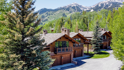 Exterior of luxury homes with mountains in the background.