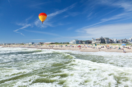 A hot air balloon flying above an ocean beach