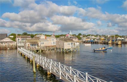 A boat glides past homes in the Nantucket Harbor.