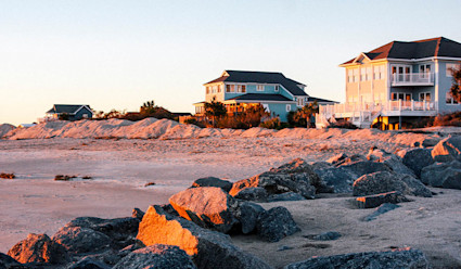 Image of the beach shore at Edisto Island featuring two luxury beach houses. 