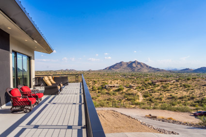 Upper, outdoor deck overlooking a desert landscape