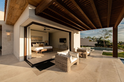 A dusk terrace with water, fire and soft lighting captures quiet luxury for warm-climate winter living.