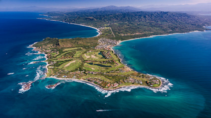 Aerial view of the Punta Mita peninsula with mountains in the distance and a full view of the coast line. 
