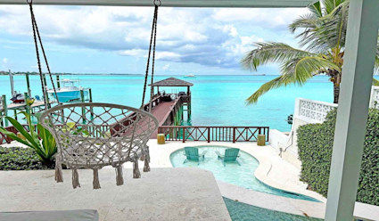 Covered outdoor area with private dock, plunge pool, and chair that extends from ceiling. 